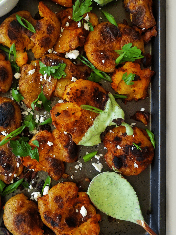 salt and vinegar smashed potatoes with herby yogurt sauce. recipe found on mandyolive.com