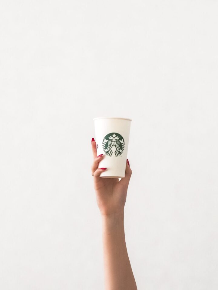 starbucks apple crisp macchiato copycat recipe. woman's arm holding starbucks cup against white bachground is pictured