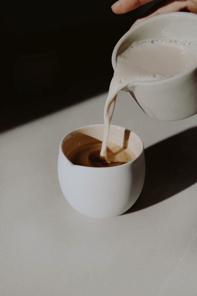 starbucks apple crisp macchiato recipe. picture of milk being poured into white cup containing espresso. 