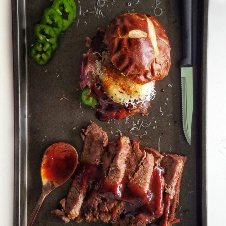 bbq brisket sandwich with sliced brisket and jalapenos on a baking sheet recipe found on mandyolive.com