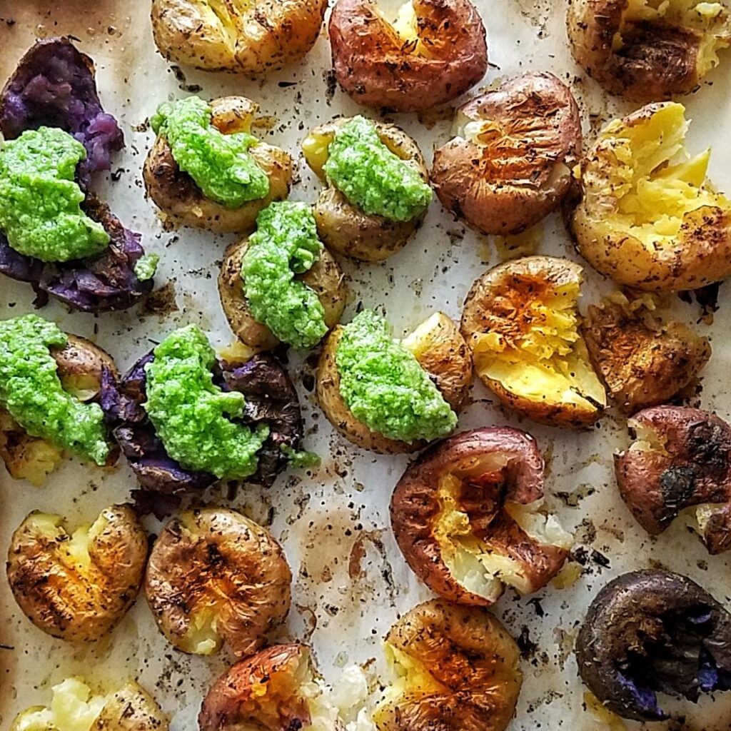 These roasted potatoes with pea pesto is a quick, easy and simple side dish made in 30 minutes or less with less than 10 ingredients. | pesto recipe without pine nuts, without nuts, homemade, healthy pesto dishes, dinner ideas, baked potatoes, fingerling potatoes, smashed potatoes, baked in the oven, how to make crispy baby, yukon gold, red potatoes