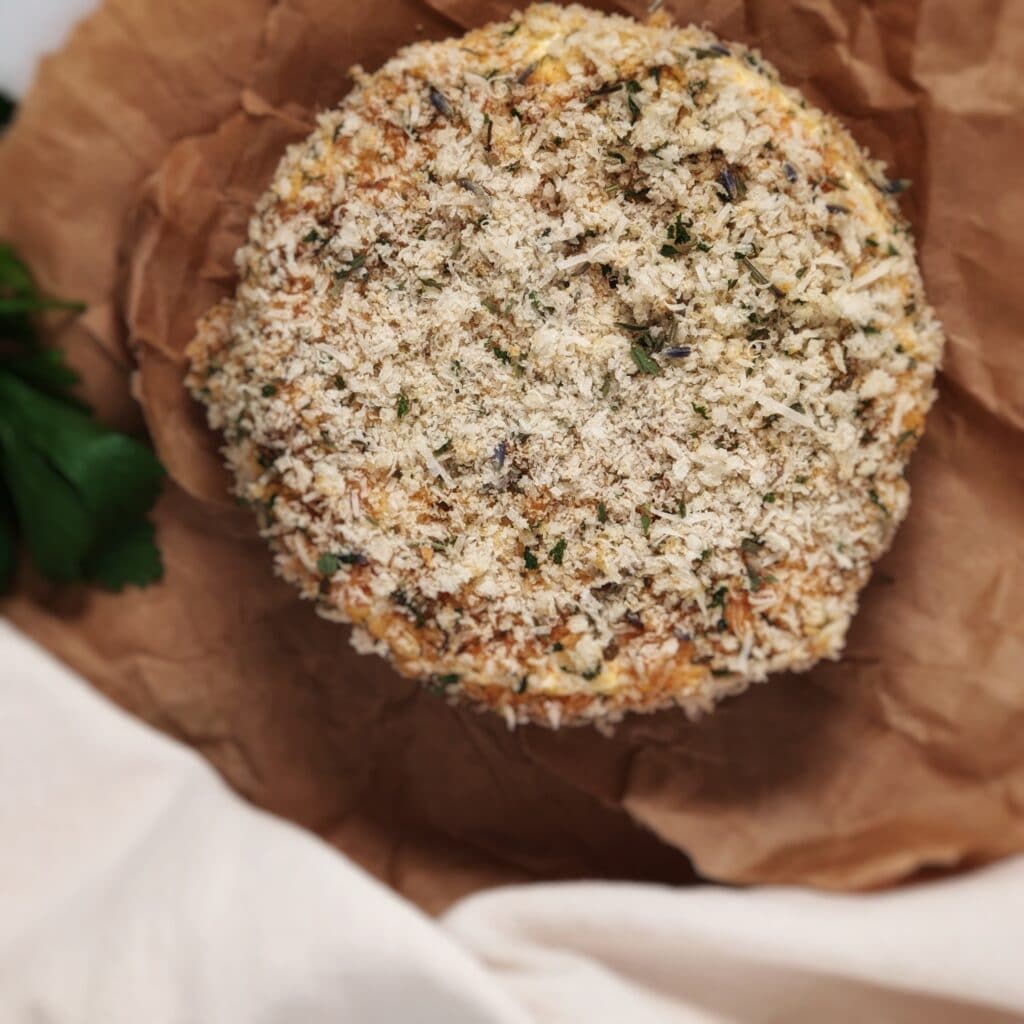 brie wheel coated in panko on brown paper