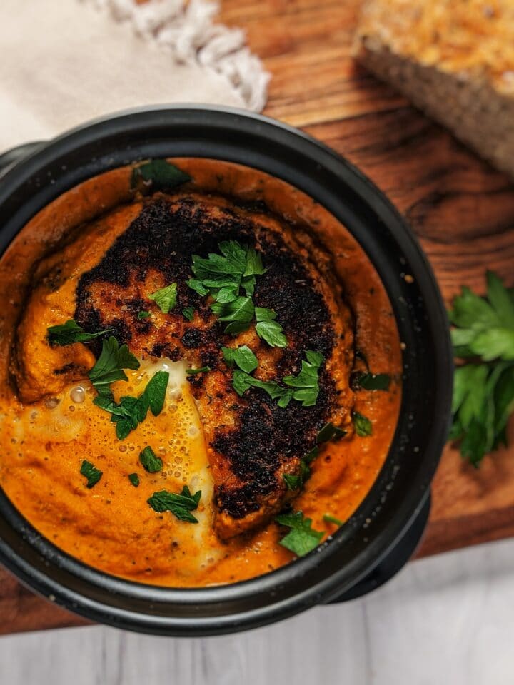 pan fried brie in romesco in dolsot stone bowl with bread on top of wooden board