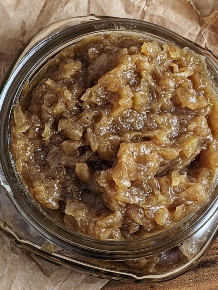 apple cider onion jam in small mason jar on top brown paper background